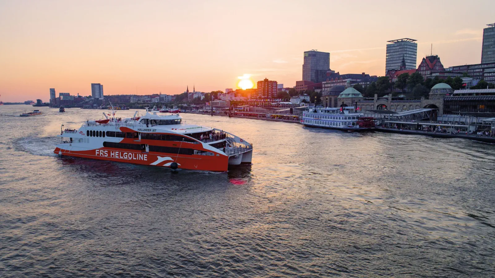 Le Halunder Jet au coucher du soleil avant d'accoster dans le port de Hambourg.
